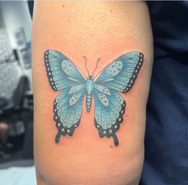 Mia More inking a client at Southernmost Tattoo, known for expert tattooing in Key West