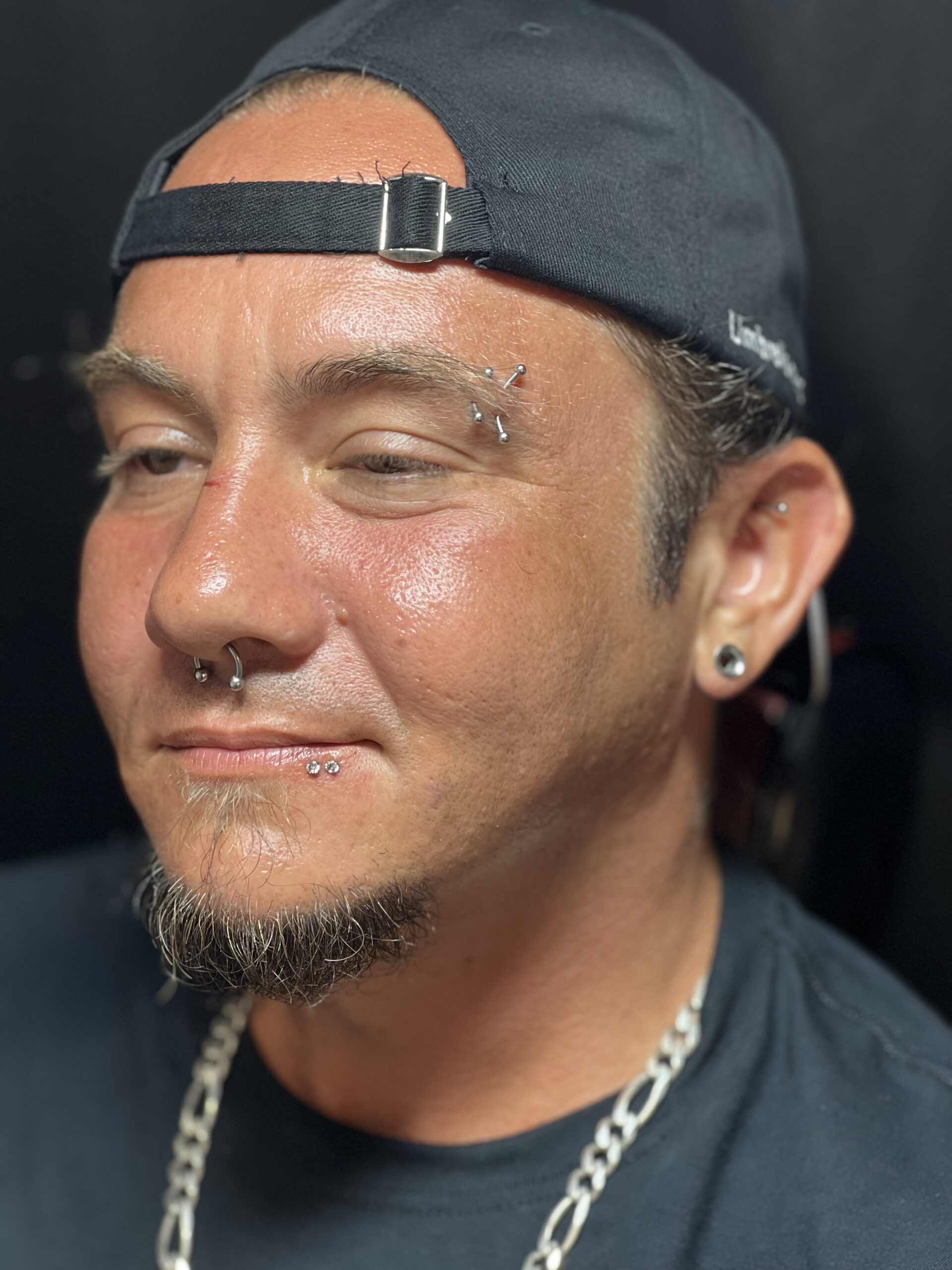 Client receiving ear piercing at Southernmost Tattoo, trusted Key West piercing and tattoo studio