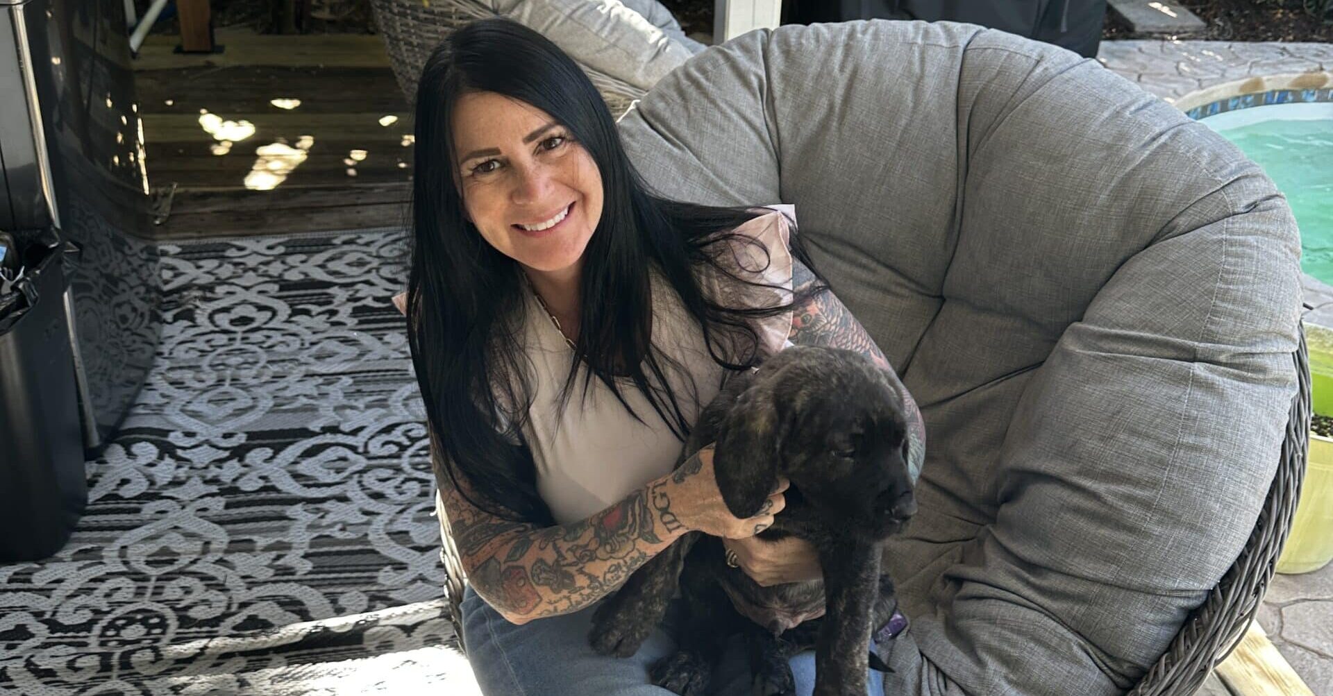 A confident, heavily tattooed woman standing in a professional setting, representing strength, individuality, and business ownership despite societal stereotypes